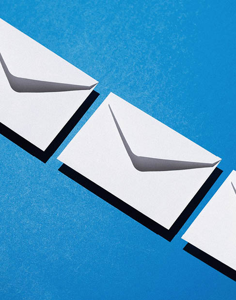 Envelopes pattern over blue background, above view with negative space