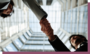 Low angle view of young business people shaking hands to each other standing in modern office building