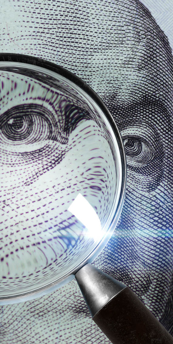 100 US Dollar under magnifying glass. close-up